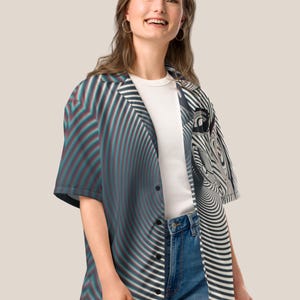 May include: A black and white striped button-up shirt with a swirling pattern. The shirt has a collar and short sleeves.