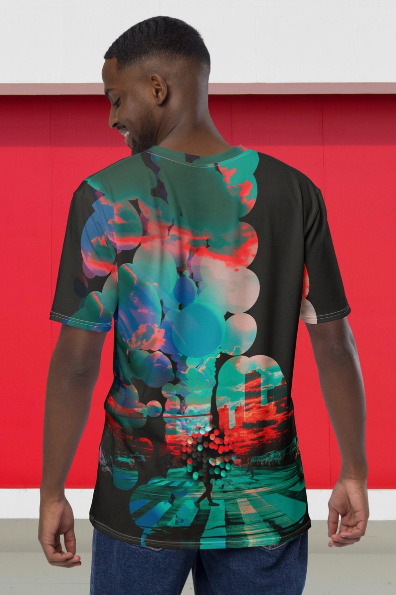 May include: A black t-shirt with a colorful graphic print of a city scene with a person walking across a crosswalk. The graphic features a pattern of overlapping circles in shades of blue, green, and red.
