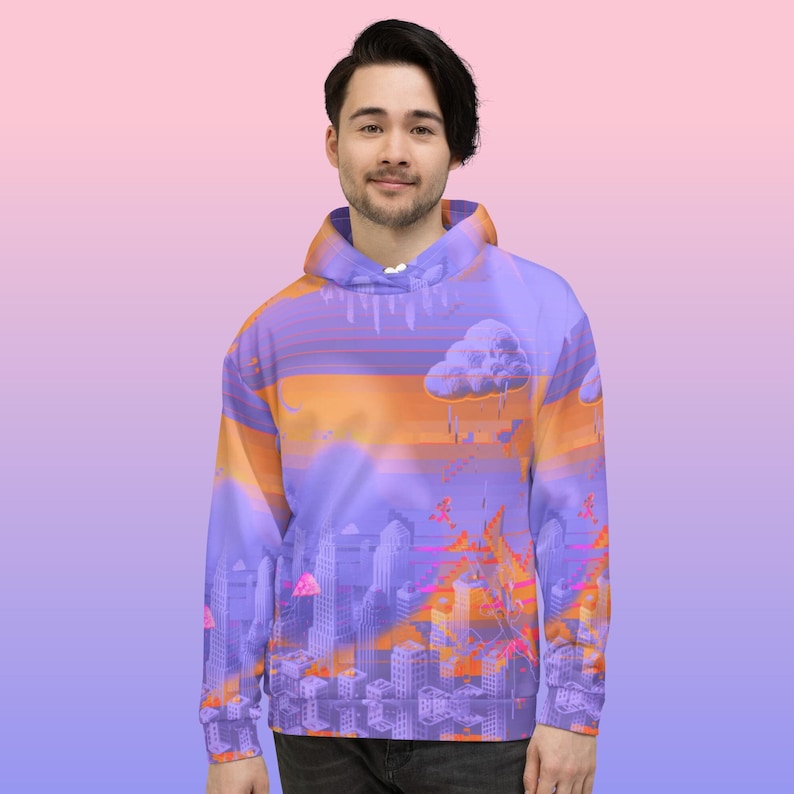 May include: A purple hoodie with a cityscape design. The design features a sunset with orange and purple hues, a cloud, and a city skyline. The hoodie is made of a soft material and has a hood and a front pocket.