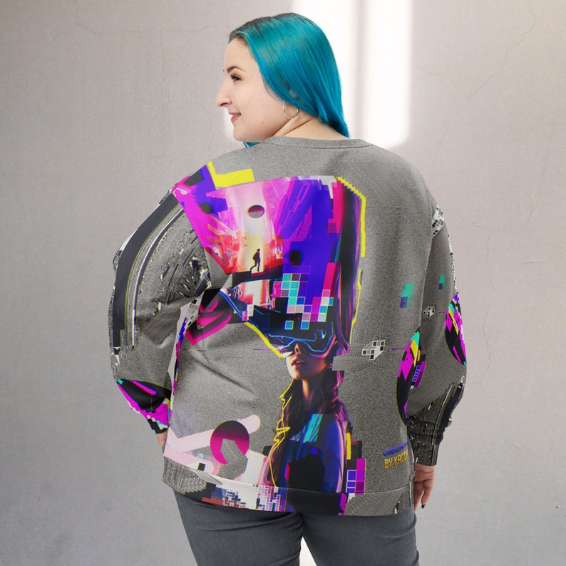 K&ouml;nnte beinhalten: Ein grauer Pullover mit einem bunten Grafikdruck, der eine Frau mit einer Virtual-Reality-Brille zeigt. Der Druck enth&auml;lt geometrische Formen, pixelartige Muster und eine futuristische Stadtlandschaft. Der Text "UNDERGROUND BY KYO" ist auf dem &Auml;rmel sichtbar.