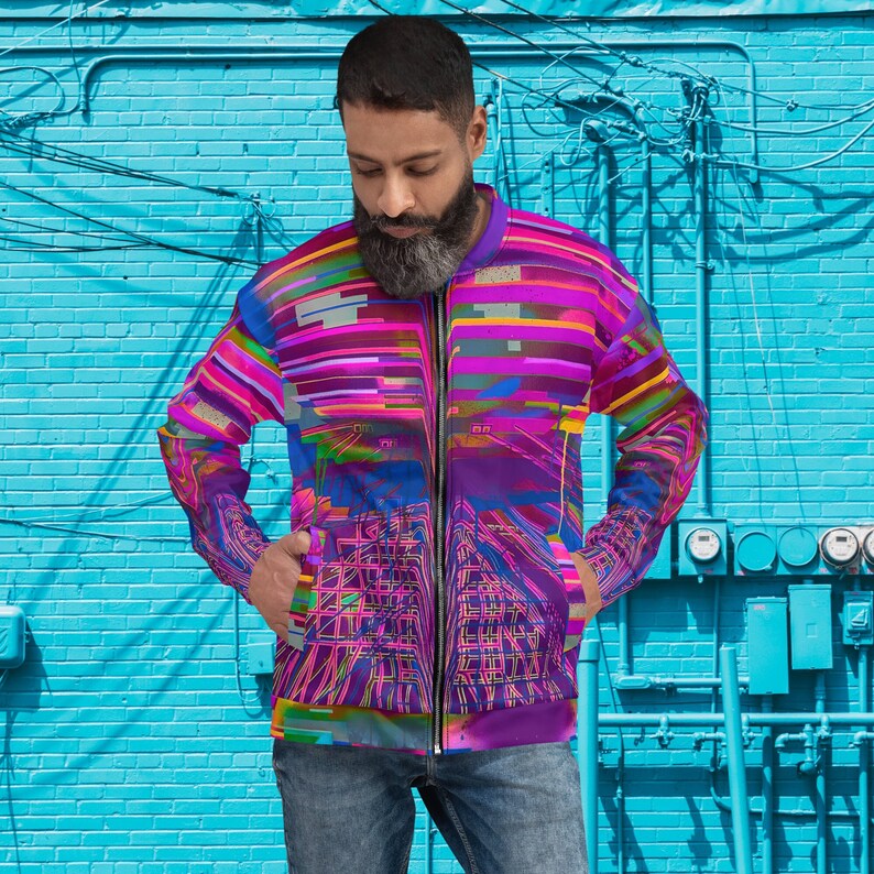 Puede incluir: Una chaqueta bomber de color morado, rosa y azul con un patr&oacute;n geom&eacute;trico. La chaqueta tiene una cremallera y dos bolsillos.