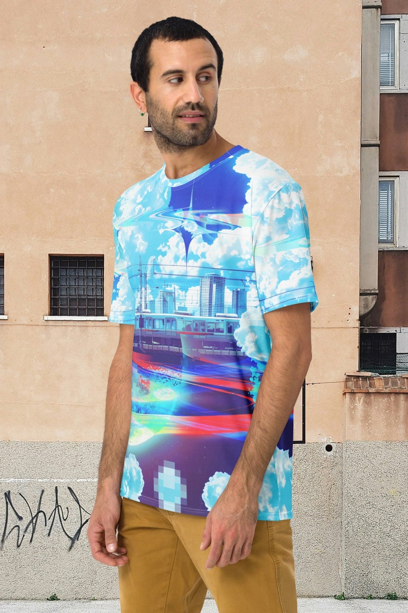 Op de afbeelding: Een blauw, wit en paars T-shirt met een grafische print van een stadsbeeld en wolken. Het shirt heeft een ronde hals en korte mouwen.