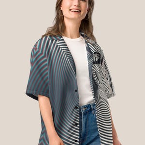 May include: A short-sleeved button-down shirt with a black, white, and red abstract pattern. The shirt has a relaxed fit and a collar.