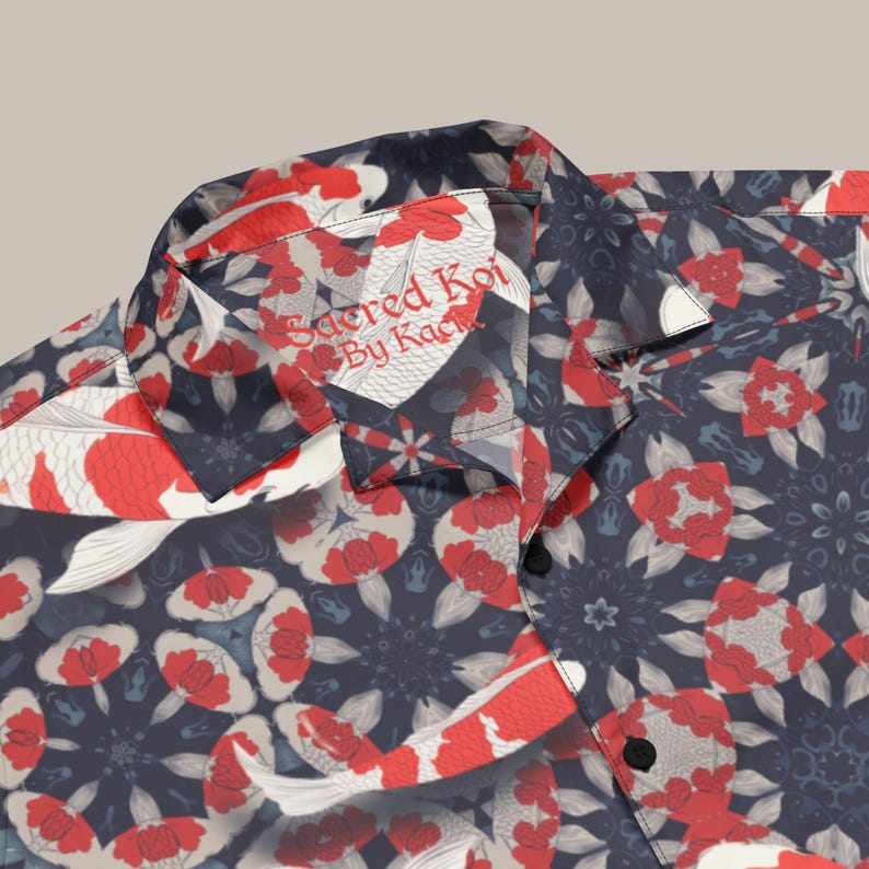 May include: Navy blue shirt with a koi fish pattern in red and white. The collar displays the text "Sacred Koi By Kaci". The design incorporates floral and geometric patterns.