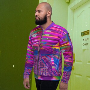Puede incluir: Una chaqueta bomber de color morado, rosa, azul y amarillo con un patr&oacute;n geom&eacute;trico. La chaqueta tiene una cremallera y un cuello de pie.
