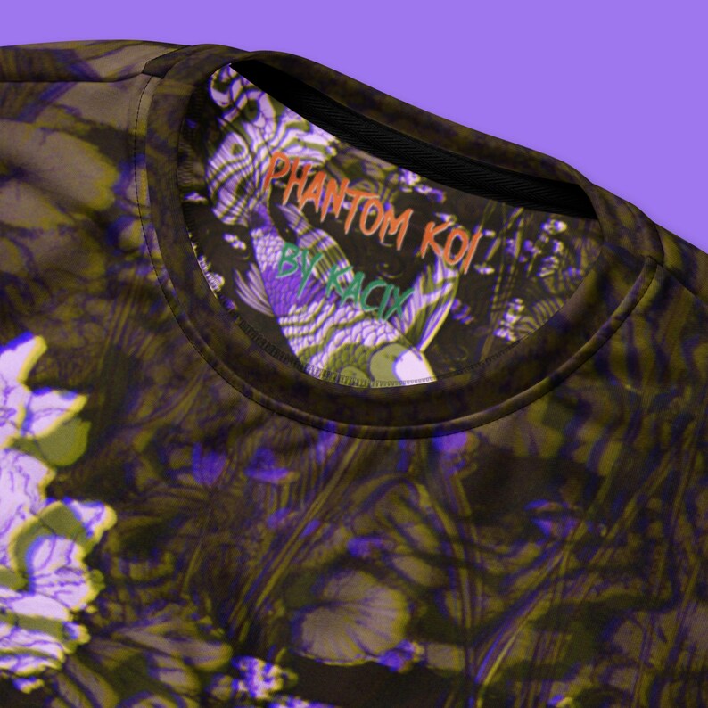 Puede incluir: Una camiseta negra con un estampado abstracto en verde oscuro, morado y blanco. La camiseta tiene un cuello redondo negro y una etiqueta que dice "PHANTOM KOI BY RACIV".