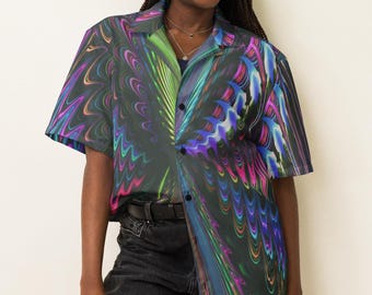 Può includere: Camicia a maniche corte con un vivace design astratto nei toni del verde, blu, rosa e viola. La camicia ha un colletto e viene indossata con jeans neri e un cappello da pescatore nero.