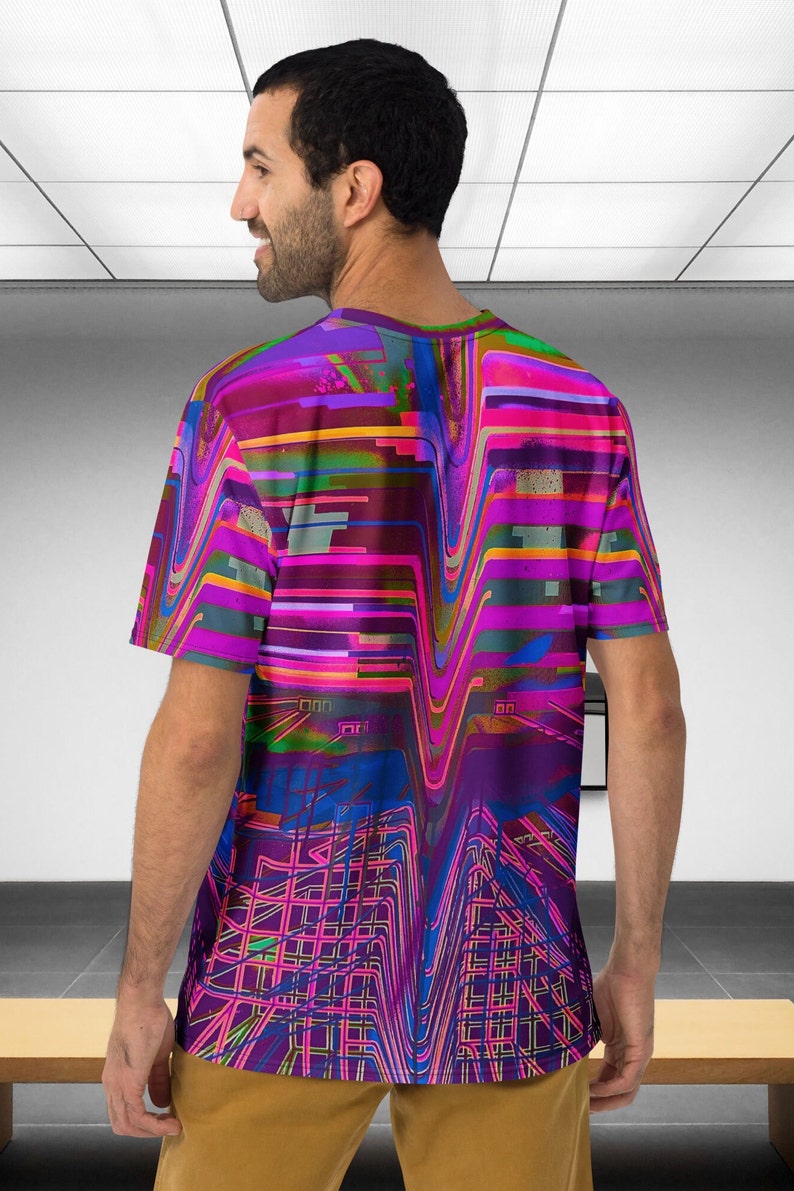 May include: A short-sleeved t-shirt with a colorful abstract design featuring wavy lines and geometric shapes in shades of pink, purple, blue, green, and yellow.