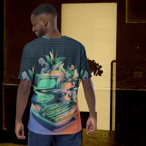 Puede incluir: Una camiseta negra y verde con un estampado gr&aacute;fico de un monitor de ordenador con un teclado y plantas tropicales. El monitor del ordenador est&aacute; distorsionado y parece que se est&aacute; derritiendo.