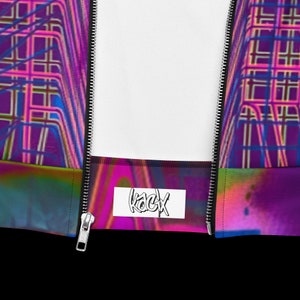 Puede incluir: Una chaqueta con cremallera de color morado, rosa y azul con una etiqueta blanca que dice "kacyx" en la parte delantera.