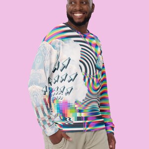 May include: A long-sleeved shirt with a colorful, abstract design featuring a pixelated pattern, clouds, and arrows. The shirt is made of a soft, comfortable fabric.