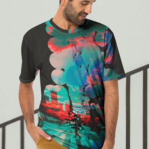 May include: A black t-shirt with a colorful abstract design featuring circles and a cityscape. The design includes shades of blue, green, pink, and red.