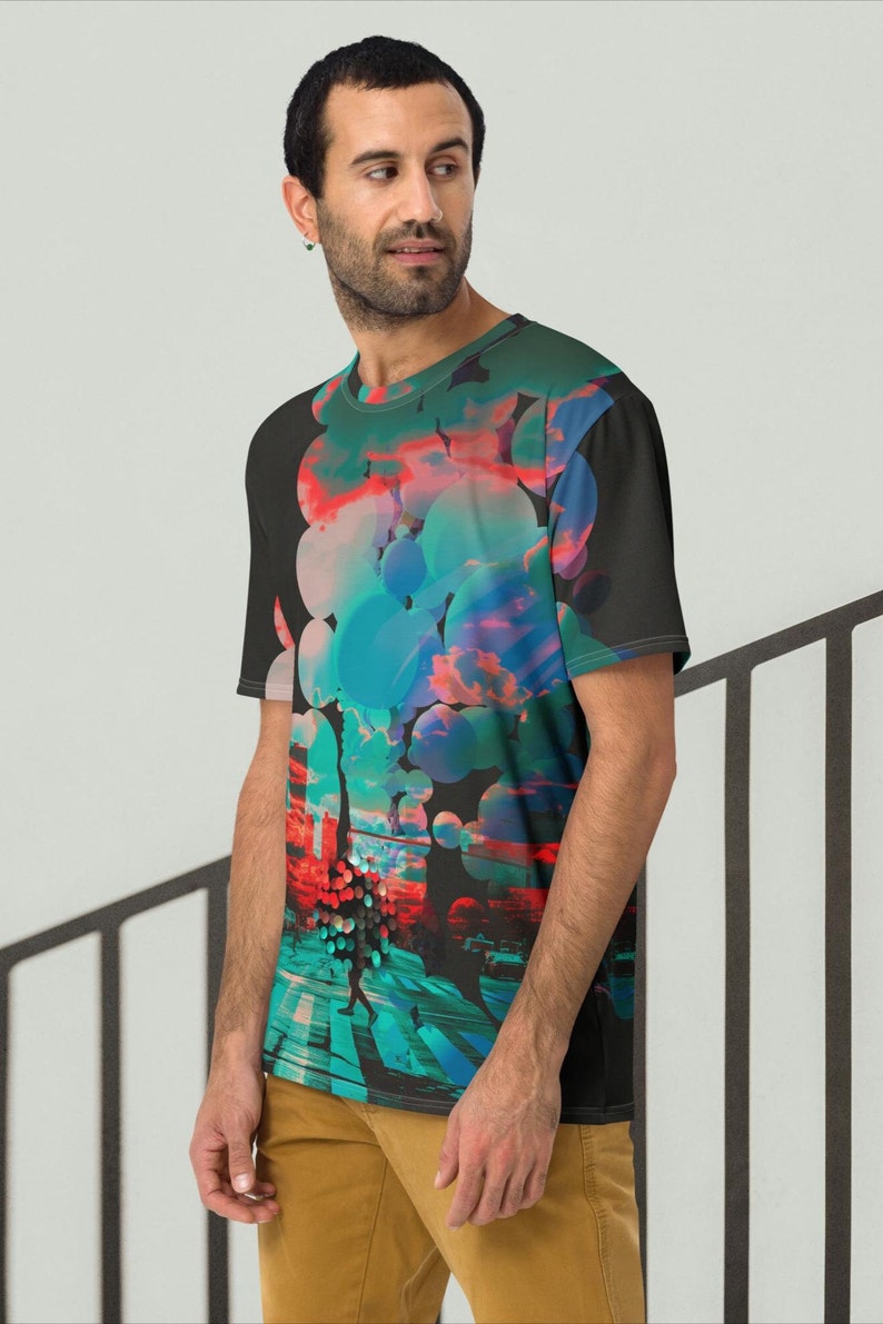 May include: A black t-shirt with a colorful abstract design featuring circles, clouds, and a cityscape. The design is in shades of blue, red, pink, and green.