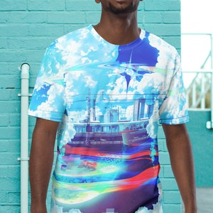 Op de afbeelding: Een blauw, wit en rood t-shirt met een grafische print van een skyline en wolken. De grafiek heeft een gepixeld effect en een regenboogkleurige streep.