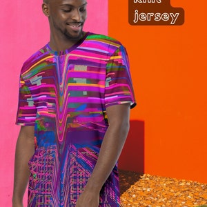 May include: A man is wearing a purple, pink, and blue t-shirt with a geometric pattern. The t-shirt has a crew neck and short sleeves. The text "Premium knit jersey" is in the upper right corner of the image.