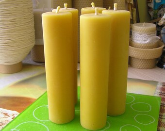 May include: Four yellow beeswax candles on a green digital scale with the word "ORION" printed on the bottom right corner. The scale has buttons labeled "UNIT", "TARE", and "ON/OFF".