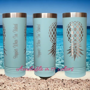 May include: Three light blue insulated tumblers with silver lids and a pineapple design. The tumblers have the text "Happier When I'm Naked" in a script font. The background shows a beach and ocean.