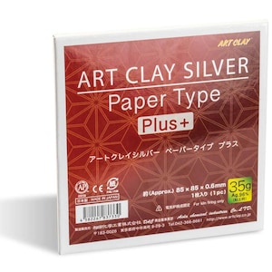 May include: A square package of Art Clay Silver Paper Type Plus, featuring a deep red background with a geometric star pattern. The white text reads Art Clay Silver Paper Type Plus, with a 35g weight label and dimensions of 85 x 85 x 0.6mm.