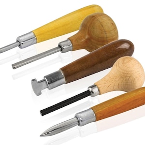May include: Four wood carving tools with metal blades. The handles are made of light and dark wood, with a variety of shapes. The blades have different profiles, including a curved gouge, a straight chisel, and a pointed tip.