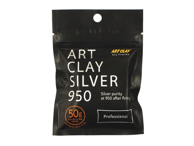May include: A black, rectangular, resealable pouch of Art Clay Silver 950. The front features white text reading Art Clay Silver 950, Professional, and Silver purity at 950 after firing. An orange circle indicates 50g, 90% Ag+Cu Alloy in Clay.