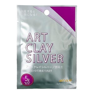 May include: A silver-colored rectangular packet of Art Clay Silver, featuring purple accents and a circular hang hole at the top. The front displays the text Art Clay Silver, 5g, and Ag.92% in clear lettering, indicating a 5-gram weight of silver clay.