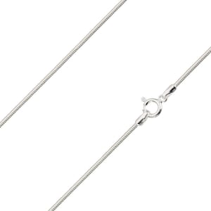 May include: A silver-coloured snake chain necklace featuring a smooth, flexible metallic texture and a circular spring ring clasp mechanism. The chain is displayed diagonally across the frame, showcasing its uniform link structure and polished finish.
