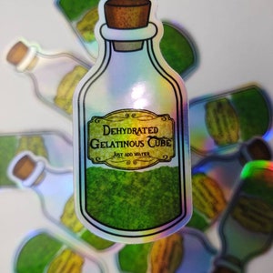 May include: A holographic sticker of a green glass bottle with a cork stopper. The label reads "Dehydrated Gelatinous Cube, Just Add Water".