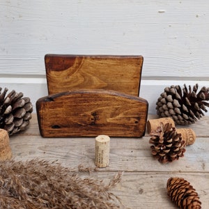 May include: A wooden wall mounted wine rack with two shelves. The rack is stained a dark brown color and has a rustic look. The rack is empty and ready to hold wine bottles.
