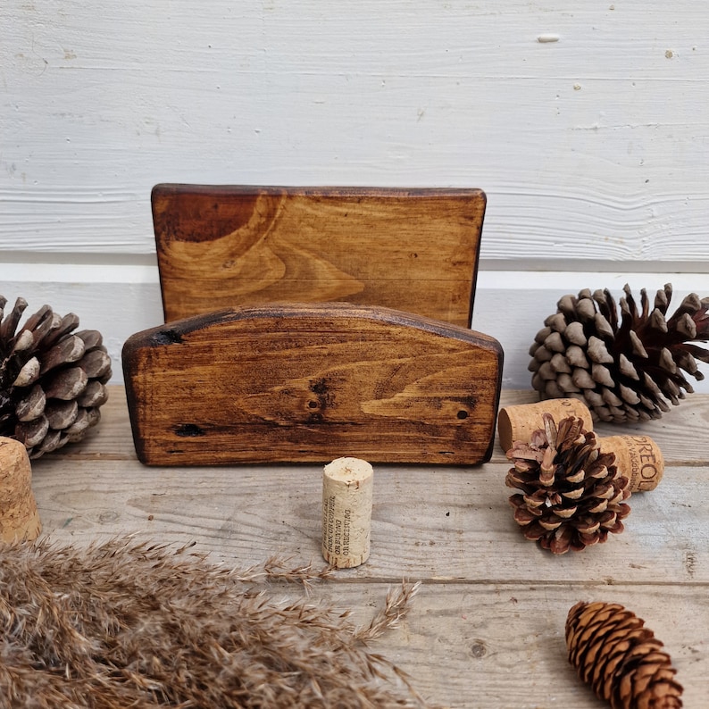 May include: A wooden wall mounted wine rack with two shelves. The rack is stained a dark brown color and has a rustic look. The rack is empty and ready to hold wine bottles.