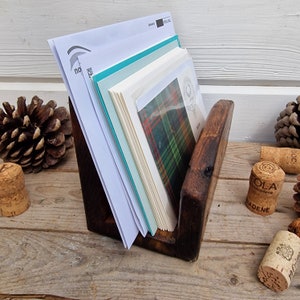 May include: A wooden card holder with a dark brown finish. The holder is filled with various cards and envelopes, including a card with a green and red plaid pattern.