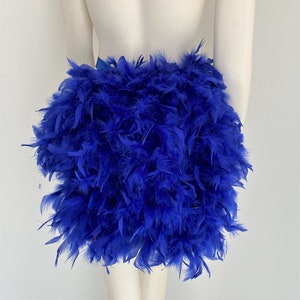 May include: A royal blue feather skirt. The skirt is made of a thick layer of feathers and is very full.