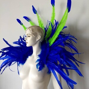 May include: A blue and green feather shoulder piece with long, flowing feathers. The shoulder piece is made of soft, fluffy feathers and is perfect for adding a touch of drama to any outfit.