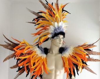 May include: A colorful feather headdress with orange, yellow, black, and white feathers. The headdress is worn by a person with a matching feather shoulder piece.