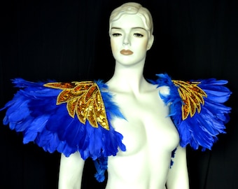 May include: A pair of blue feather shoulder pieces with gold sequined accents. The shoulder pieces are worn on a mannequin.