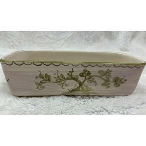 Peut inclure: Un pot rectangulaire en céramique avec un glaçage rose clair et un motif floral vert. Le pot a un bord festonné et est parfait pour présenter de petites plantes ou des fleurs.