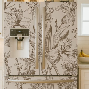 May include: A refrigerator with a floral design. The refrigerator has a light beige background with a brown floral pattern. The refrigerator has stainless steel handles and a water dispenser. The top of the refrigerator has jars and lanterns.