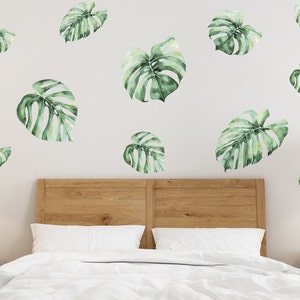 Monstera Wall Decal in the bedroom above wooden double bed you can see on the photo. Jungle theme wall decal in the bedroom photo.