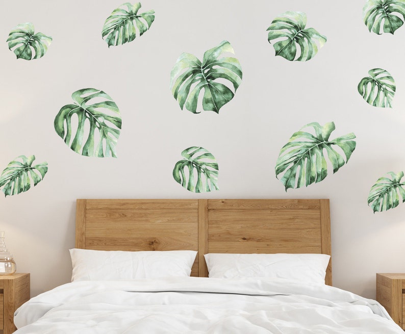 Monstera Wall Decal in the bedroom above wooden double bed you can see on the photo. Jungle theme wall decal in the bedroom photo.
