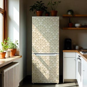 May include: A beige refrigerator with a repeating floral pattern in shades of beige and gray. The refrigerator has stainless steel handles and a water dispenser. Jars of cookies and decorative lanterns sit on top.