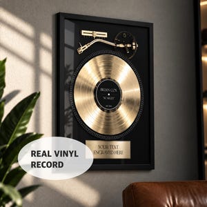 May include: A framed gold vinyl record display featuring a gold-toned turntable tonearm and a central black label with the text BRIAN COX SCARLET EST 2021. Below the record is a rectangular gold plaque with the text YOUR TEXT ENGRAVED HERE.