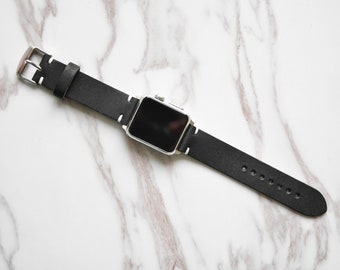 May include: A black leather watch band with a silver buckle and a black watch face.