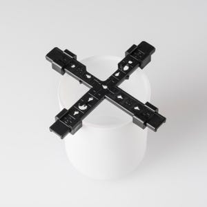 May include: Black plastic plant support with a grid pattern and multiple holes. The support is designed to fit around a round pot.