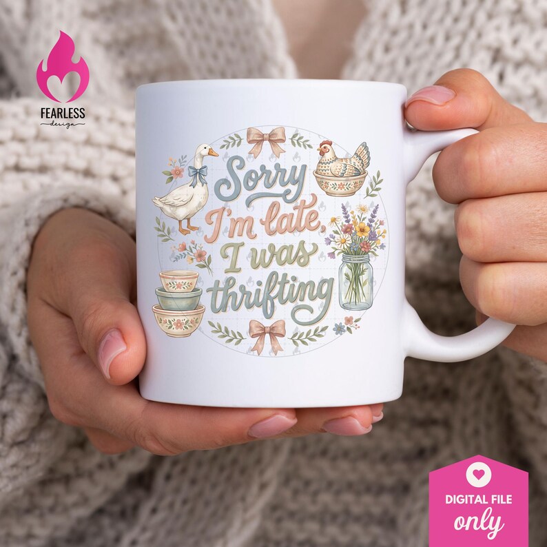 May include: White ceramic mug with the text "Sorry I'm late, I was thrifting" surrounded by illustrations of a goose, chicken, flowers, and bowls. The mug has a handle and is held by a person.