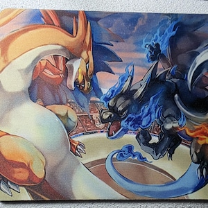 May include: A rectangular mousepad featuring a vibrant illustration of two fantasy creatures in a battle scene. One creature is orange and white, the other is black and blue, with flames and a stadium background.