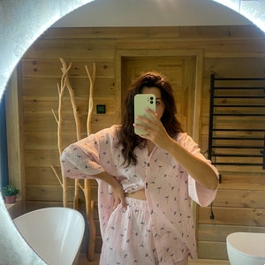 Peut inclure: Un ensemble de pyjama rose &agrave; imprim&eacute; pissenlit. Le haut a un devant boutonn&eacute; et des manches courtes. Le short a une taille &eacute;lastique.