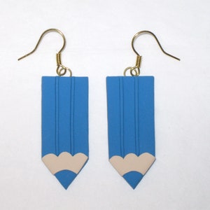 May include: A pair of blue pencil-shaped earrings with a white eraser detail. The earrings have gold hooks.