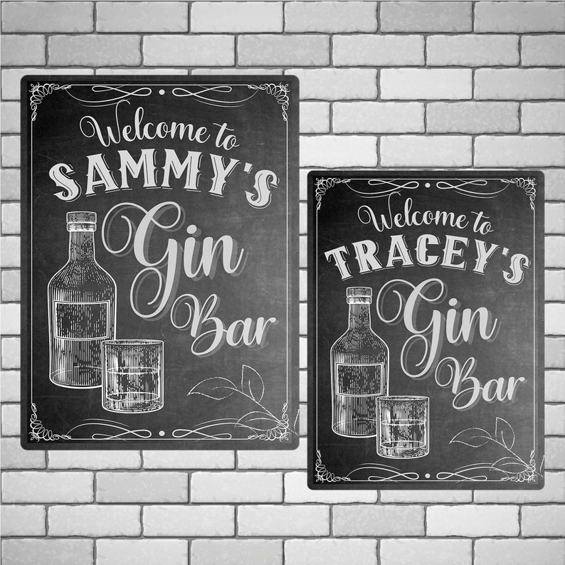 May include: Two black chalkboard signs with white lettering. The signs say "Welcome to Sammy's Gin Bar" and "Welcome to Tracey's Gin Bar". Each sign has a drawing of a bottle of gin and a glass.