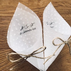 May include: Two white paper cones with a dotted pattern and tied with twine. The cones are decorated with black calligraphy that reads "A & F 12 Settembre 2019".