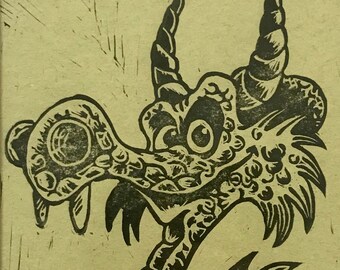 Blockprint of a cartoon dragon on light green paper - Framed in glass - Printed by hand