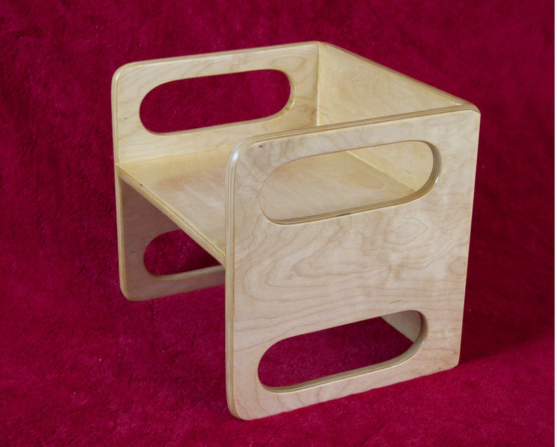 May include: A wooden step stool with rounded edges and three oval cutouts. The stool is made of light wood with a natural finish.
